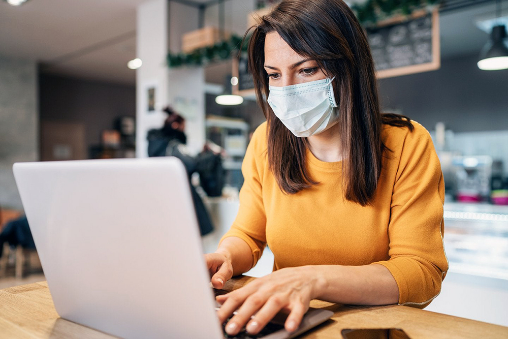 Woman with a face mask on a laptop